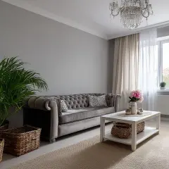 Elegancka sofa chesterfield i kryształowy żyrandol tworzą styl boho glamour wnętrza. Wazon z kwiatami i wiklinowe kosze dodają przytulności.