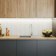 Nowoczesna kuchnia z drewnianymi frontami i szarymi szafkami. Blat kuchenny z naturalnego drewna, zlew, kran, miska z bananami i przyprawy. Wymiana blatu kuchennego nada świeżości.