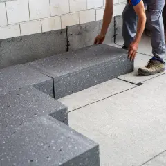 Układanie płyt styropianowych na izolacji. Kluczowe jest, czy folia jest na styropian czy pod.