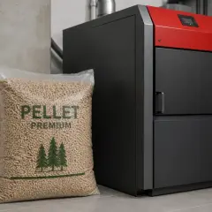 Worek z pelletem premium obok nowoczesnego kotła. Zastanawiasz się, do kiedy można palić pelletem? To ekologiczne paliwo grzewcze.