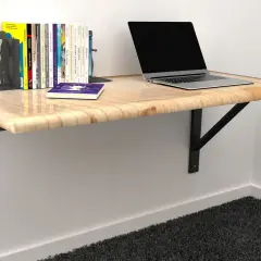 Solidne mocowanie blatu do ściany, na którym stoi laptop i książki. Idealne do małych przestrzeni.