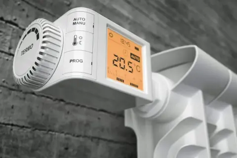 Nowoczesne rodzaje głowic termostatycznych na grzejniku: cyfrowy wyświetlacz pokazuje 20.5°C, tryb AUTO.