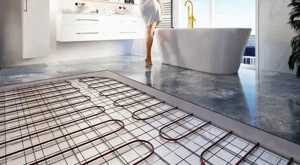 Instalacja ogrzewania podłogowego w łazience. Wady tej technologii mogą obejmować długi czas nagrzewania i trudności w naprawie.