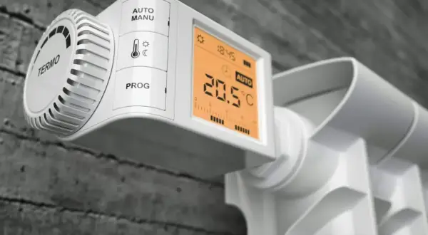 Nowoczesne rodzaje głowic termostatycznych na grzejniku: cyfrowy wyświetlacz pokazuje 20.5°C, tryb AUTO.