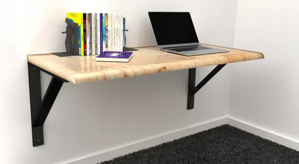 Solidne mocowanie blatu do ściany, na którym stoi laptop i książki. Idealne do małych przestrzeni.