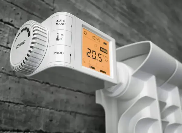 Nowoczesne rodzaje głowic termostatycznych na grzejniku: cyfrowy wyświetlacz pokazuje 20.5°C, tryb AUTO.