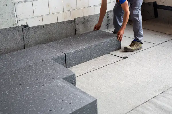 Układanie płyt styropianowych na izolacji. Kluczowe jest, czy folia jest na styropian czy pod.